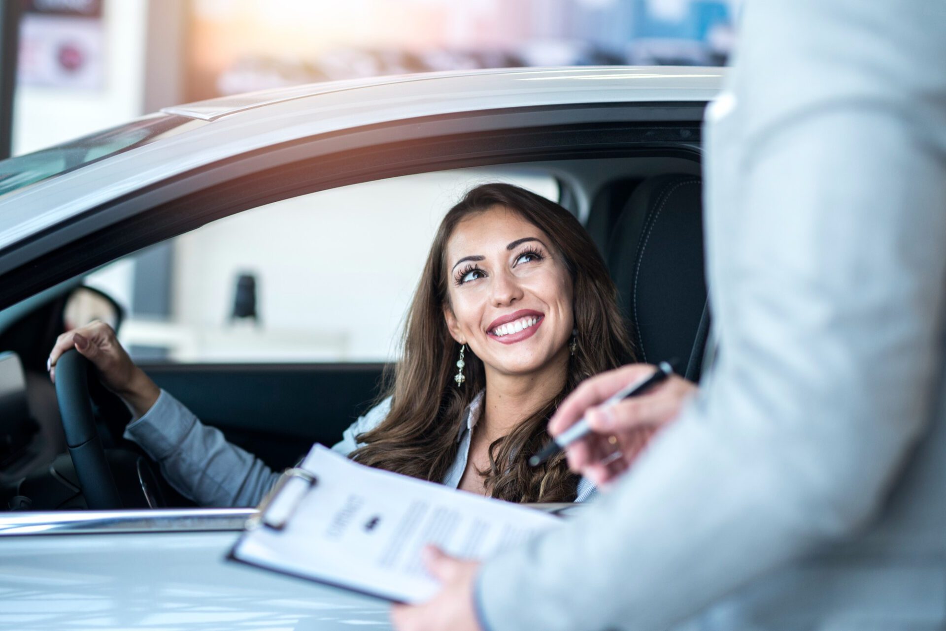 Happy customer buying brand new car at local car dealership Happy customer buying brand new car at local car dealership